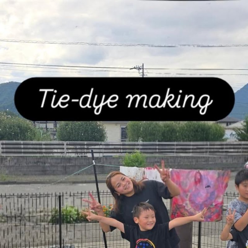 タイダイ染めの布を広げる子どもたち